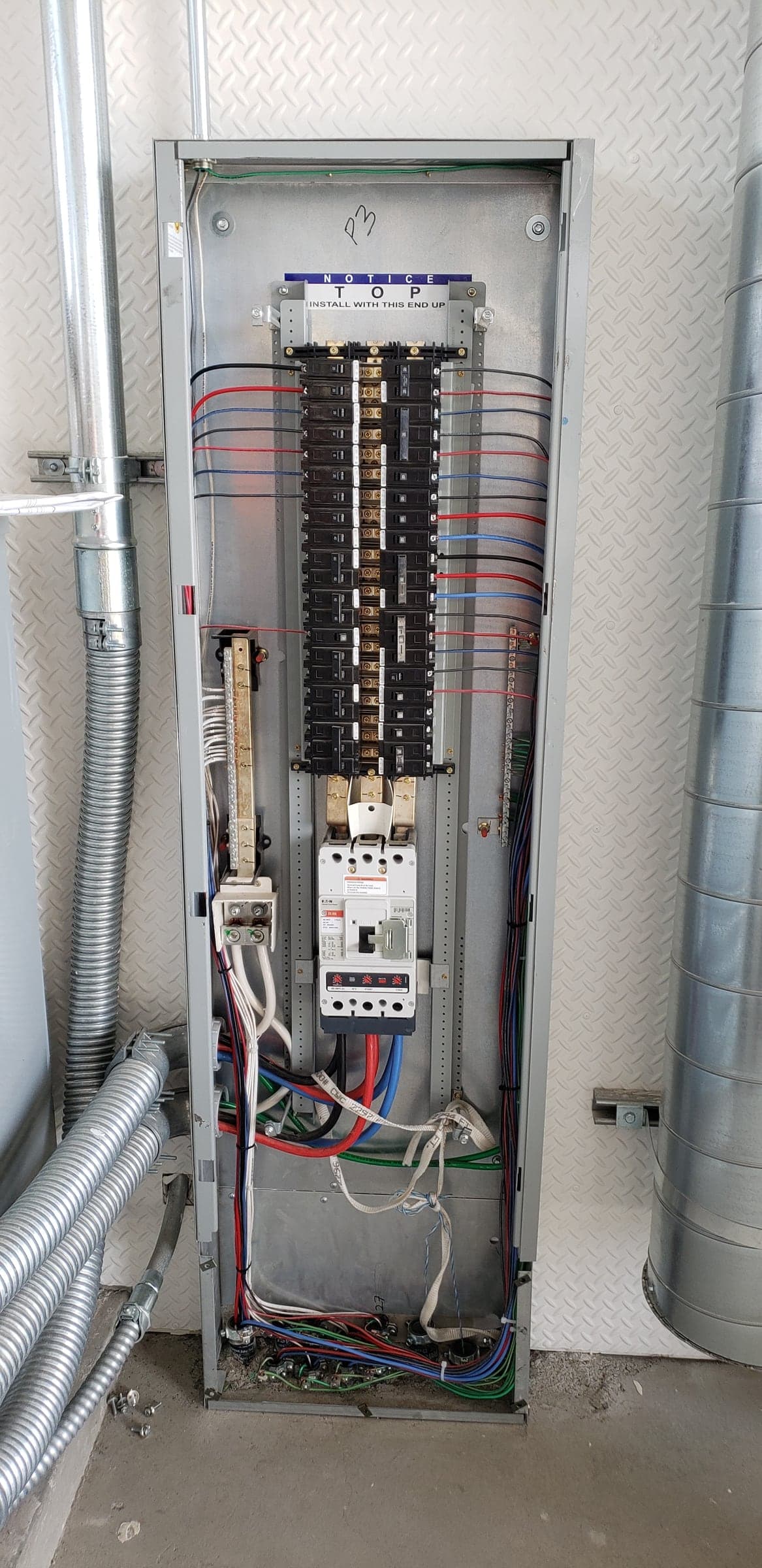 Commercial panelboard interior with a main breaker and neatly combed branch-circuit conductors in Sacramento, CA